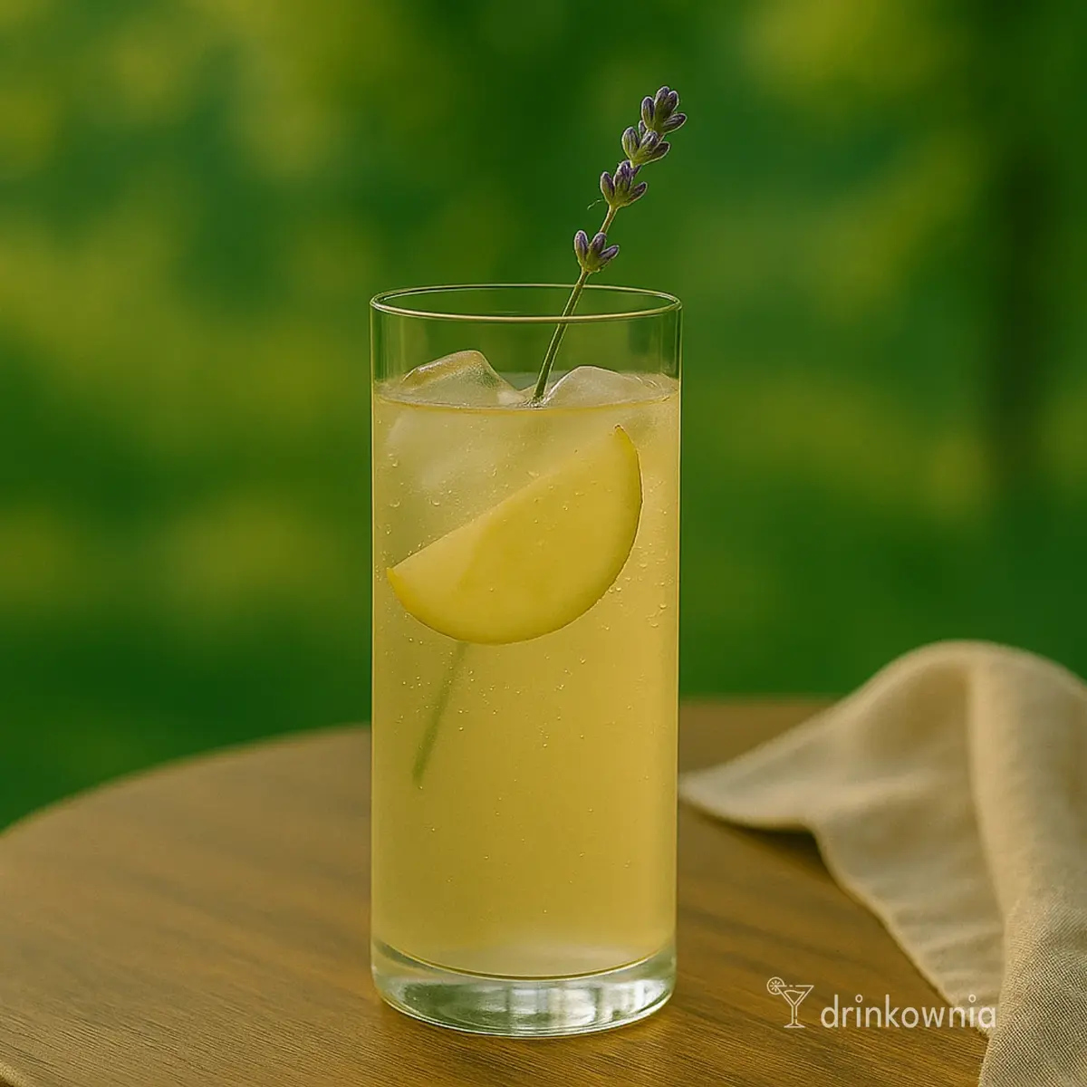 Szklanka lemoniady z białym winem i lawendą na tle zieleni – lekki, wiosenny drink z winem i nutą kwiatową.